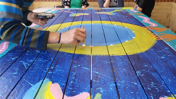 Children working on a collaborative artwork with artist Noeleen Hamlett, on the surface of the communal patio table, 2014. Images courtesy of CAHS.